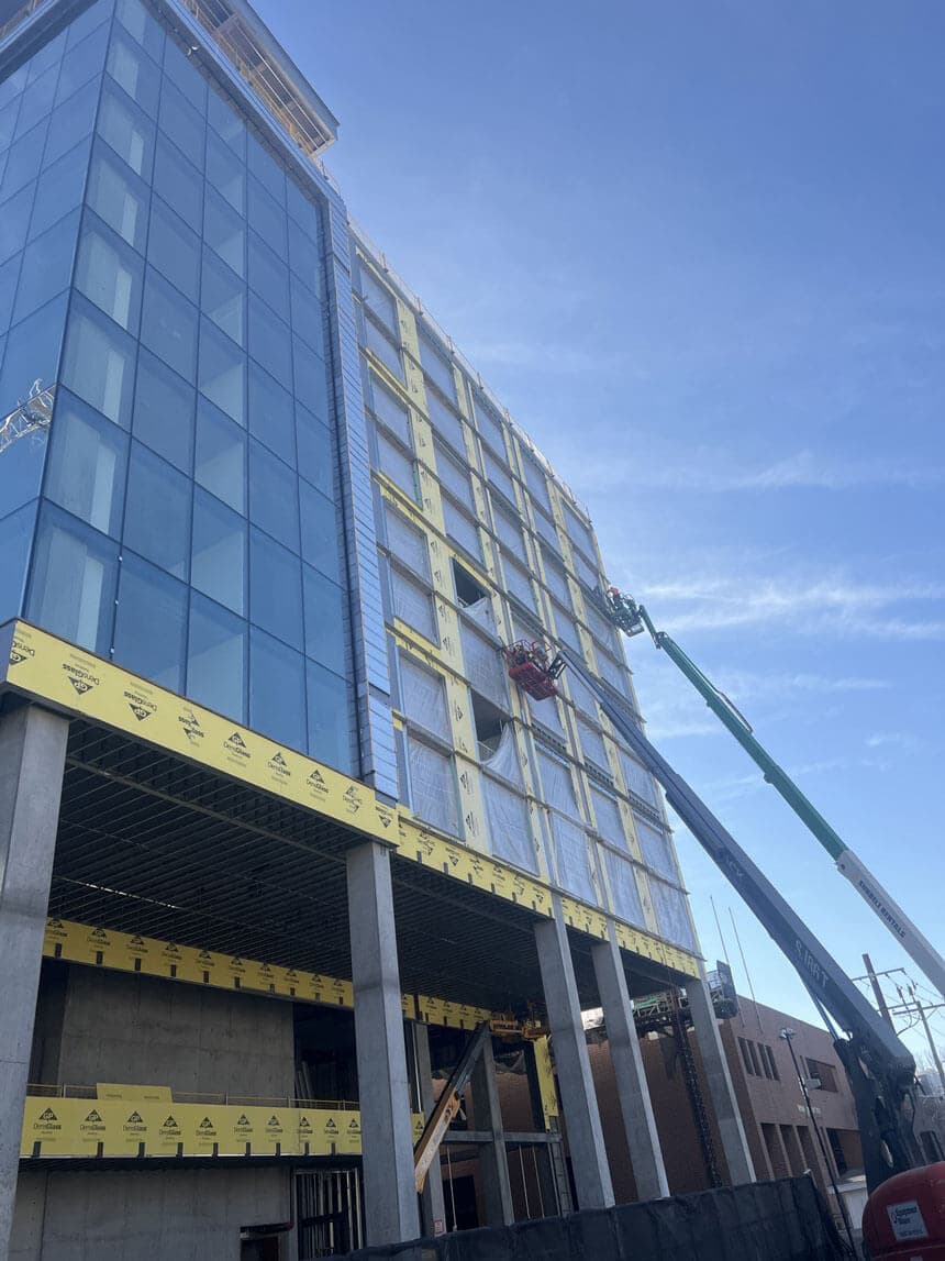 Panelized steel exterior wall system being installed on a mid rise commercial building